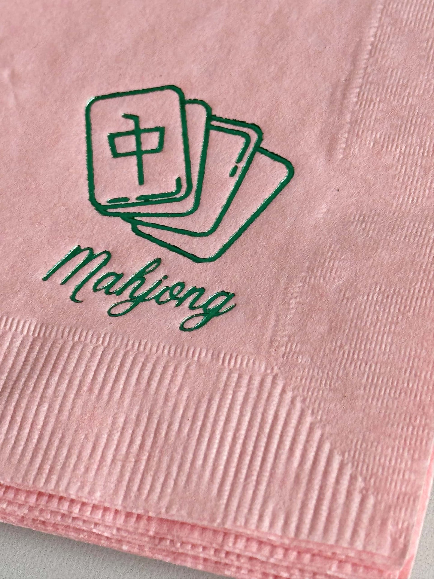 Elevate your game night with our exquisite Pink Mahjong Cocktail Napkins, designed to bring a touch of style to your gatherings. With a delicate green foil mahjong tile icon and the word "mahjong" elegantly scripted