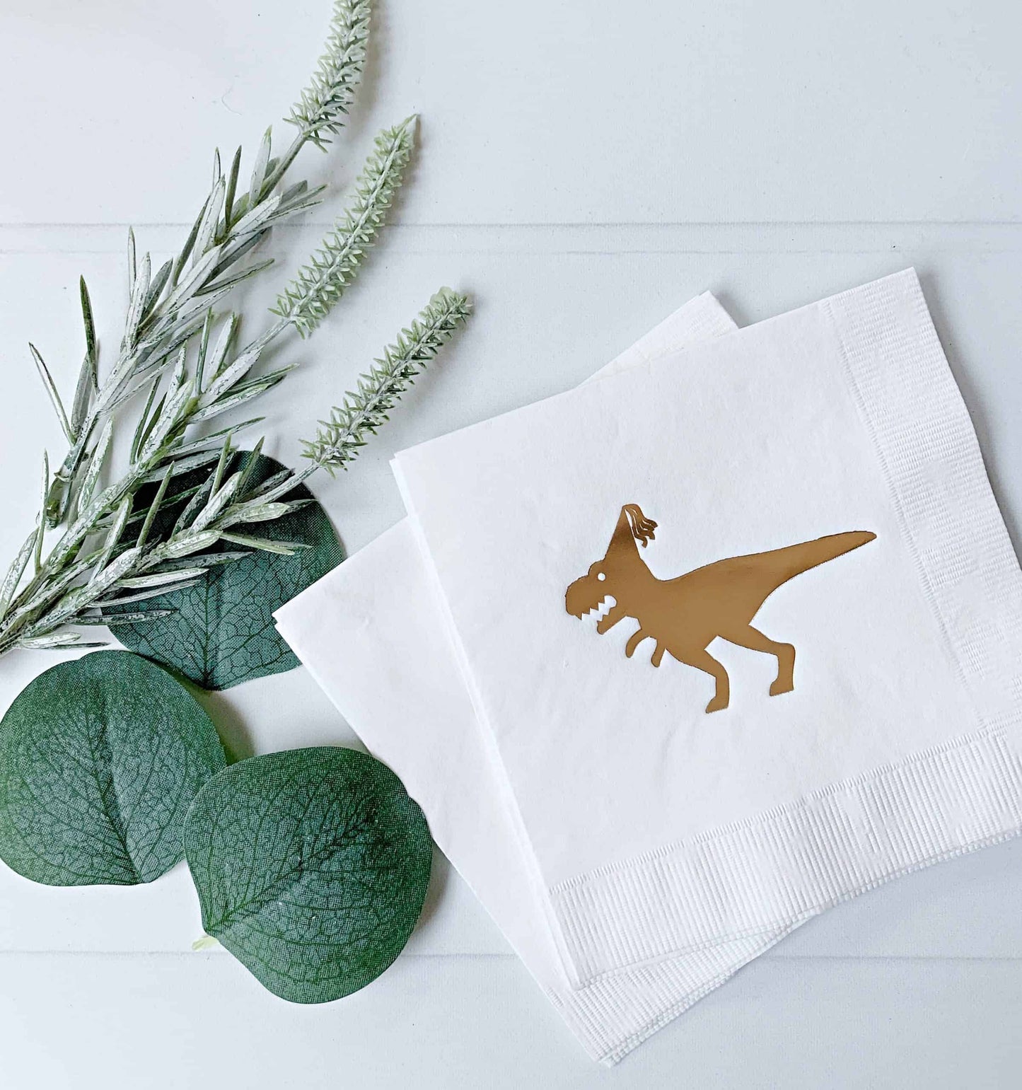 Make your birthday celebration a roaring success with these Gold on White Dinosaur Napkins! These EnFete original napkins feature a fun and sassy dinosaur design in shiny gold foil that is perfect for a 50 and fabulous party or any dinosaur-themed event. These napkins are ideal for drinks, desserts, or as a finishing touch to your table setting. A great finishing touch to your party decor, these napkins pair perfectly with the matching tableware, balloons, and other dinosaur-themed party supplies available