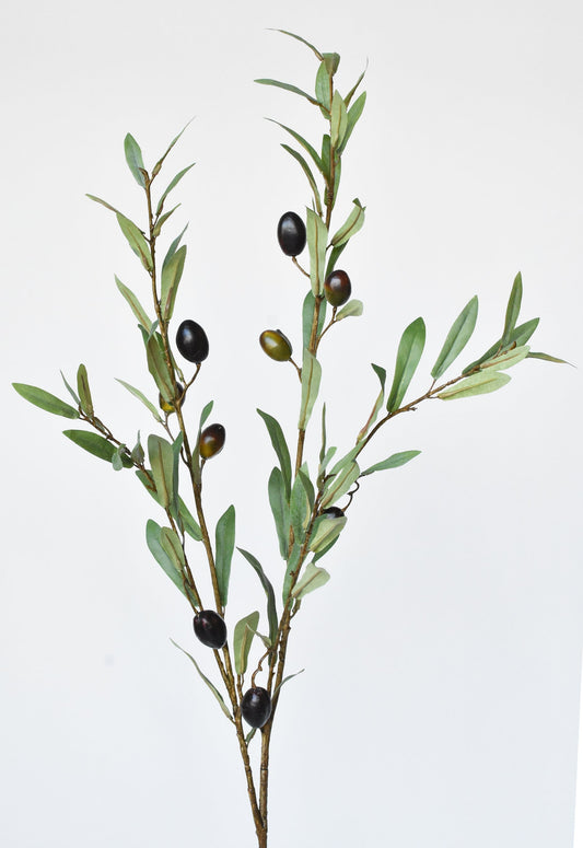 Artificial olive branch with green leaves and black olives on a white background