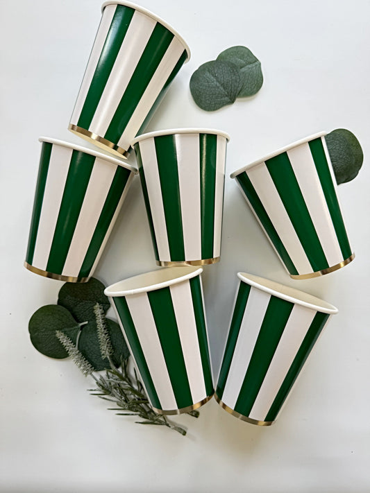 Green and white striped paper cups on a light background with green leaves.