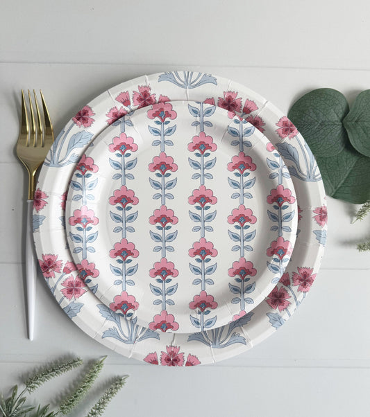 Floral-patterned block print designer paper plates stacked with a fork on a light gray background
