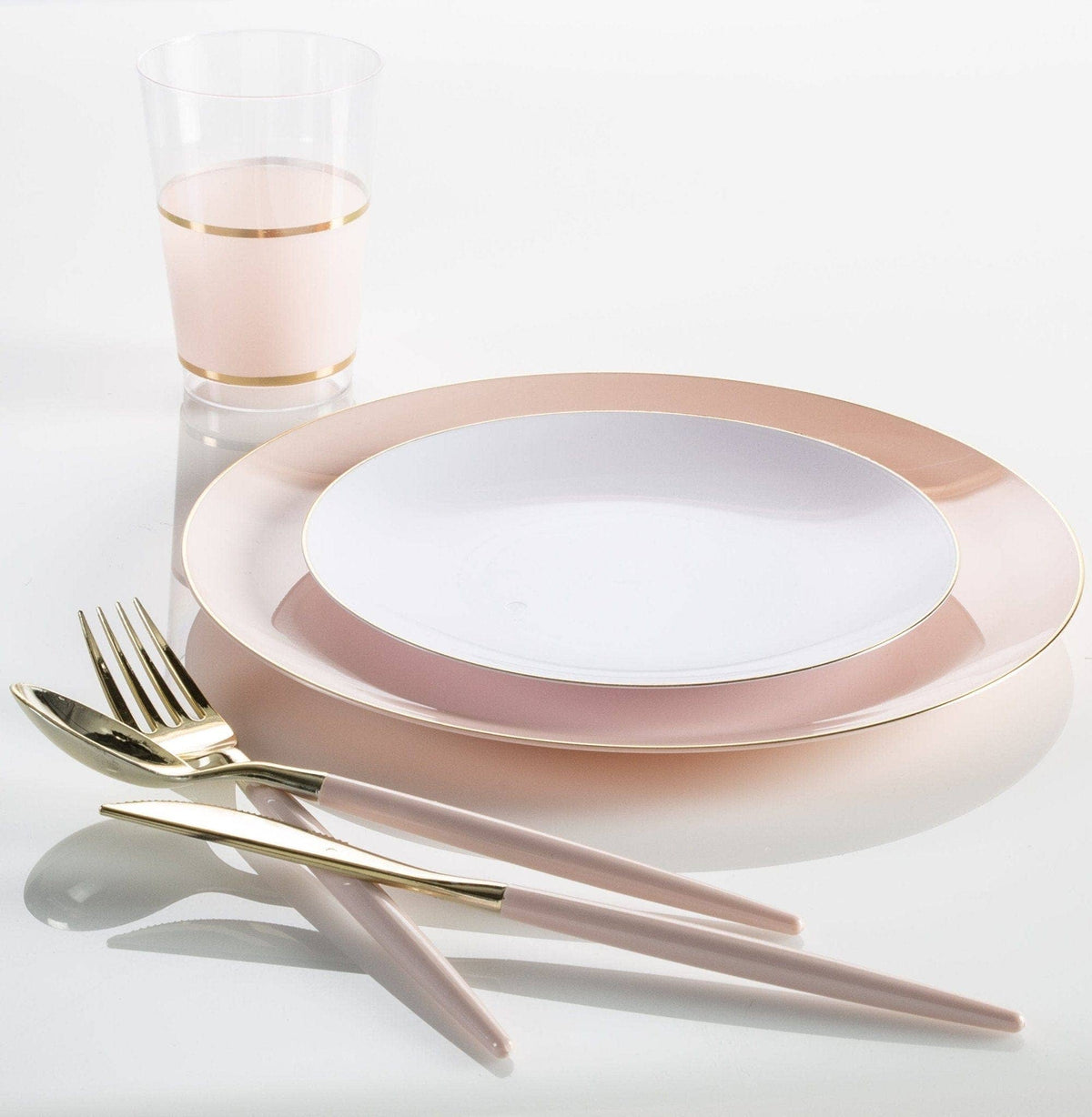 Pink and gold dinnerware set on a white background