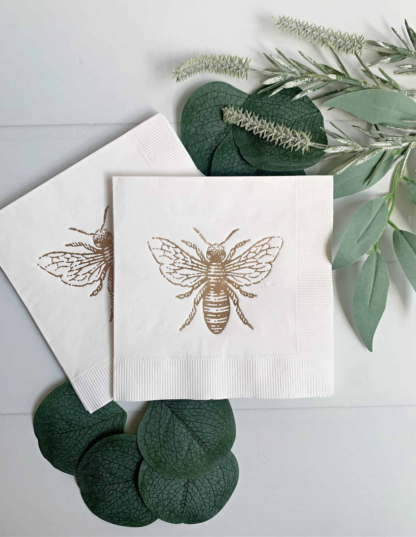 Gorgeous gold foiled Honey Bee Beverage Napkins. These 3-ply cocktail napkins measure 5" and feature a gold foil honey bee on a white napkins.