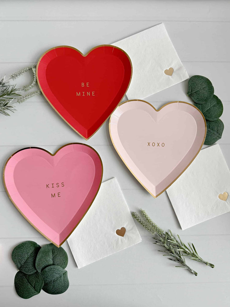 Valentine's Day heart plates, 3 shades of pink and red with sweet conversation hearts like sayings. Shown with our dainty heart cocktail napkins that are perfect for Galentine's Day.