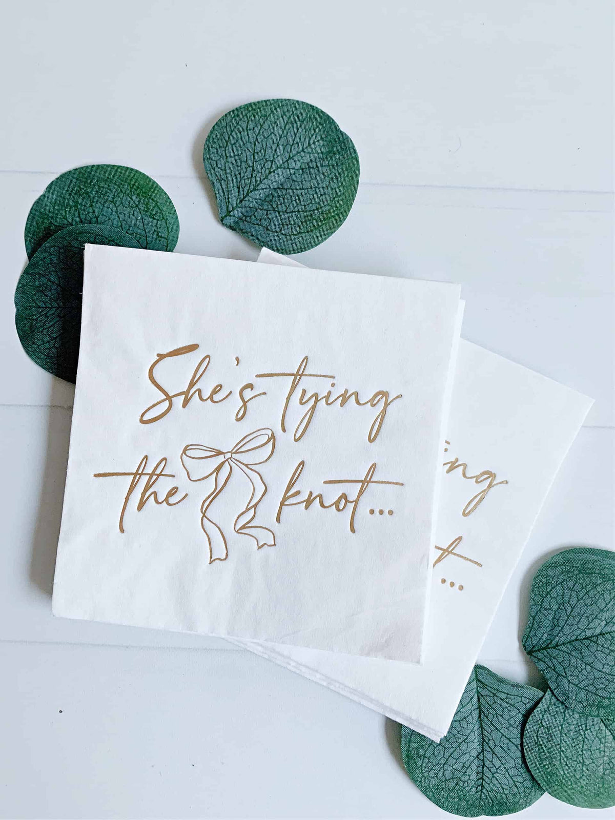 
    She's Tying the Knot Gold Cocktail Napkin | Set of 16 White, the designer-recommended anchor napkin for the She's Tying the Knot Bridal Shower - Bow &amp; Floral Party Decorations collection
  