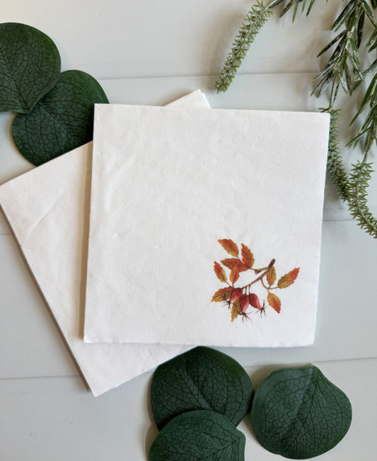 Amber, Red, Orange and a hint of Olive green full color watercolor leaves on a white cocktail napkin.