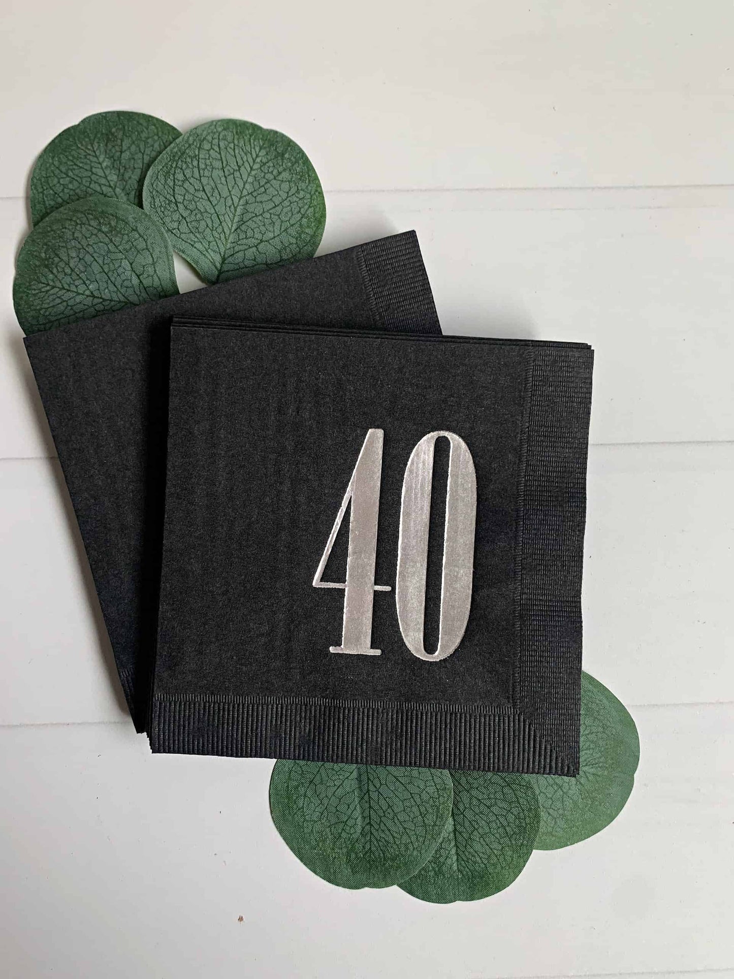 Sharp retro number 40 on a black napkin in shiny silver foil. Both modern and nostalgic. Perfect for a 40th birthday party for this special milestone. Cocktail sized napkins.