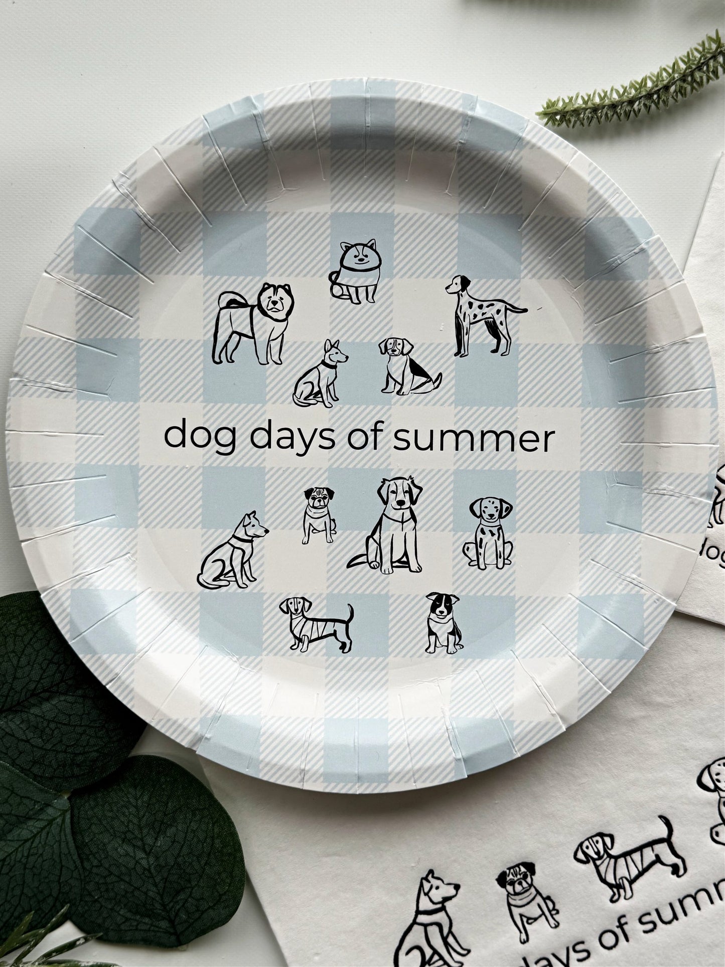 Introducing the charming "Dog Days of Summer Cake Plate" set, featuring a delightful design of playful pen illustration dogs frolicking on a cool ice blue gingham background. This set includes 8 paper cake plates, each measuring 7 inches in size, making them ideal for serving up slices of cake or small bites at your next summer gathering.
