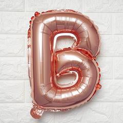Rose gold letter 'B' balloon on a white textured background