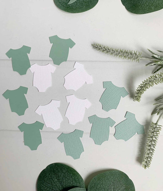 A fun addition to your baby shower party tables - these sage and white baby onesie cutouts can be spread around to decorate for a gender reveal or baby shower.