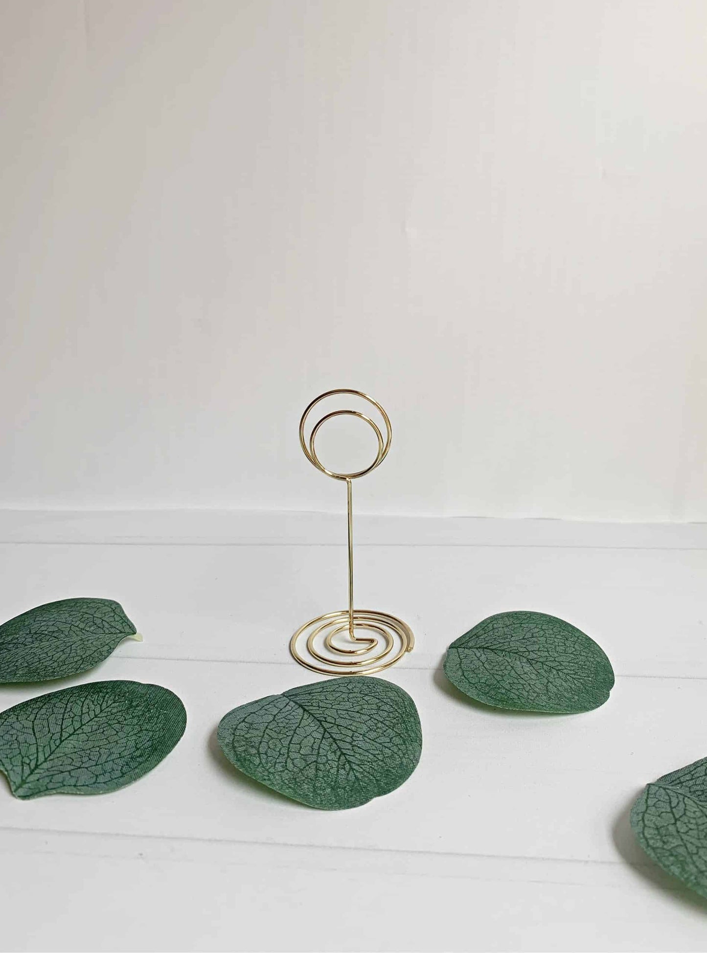 Elevate the elegance of your wedding decor with our exquisite Gold Wedding Table Number Stands. Crafted from durable metal in a radiant gold finish, these table number stands are designed to add a touch of sophistication and charm to your special day.