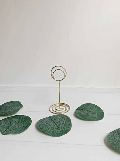 Elevate the elegance of your wedding decor with our exquisite Gold Wedding Table Number Stands. Crafted from durable metal in a radiant gold finish, these table number stands are designed to add a touch of sophistication and charm to your special day.