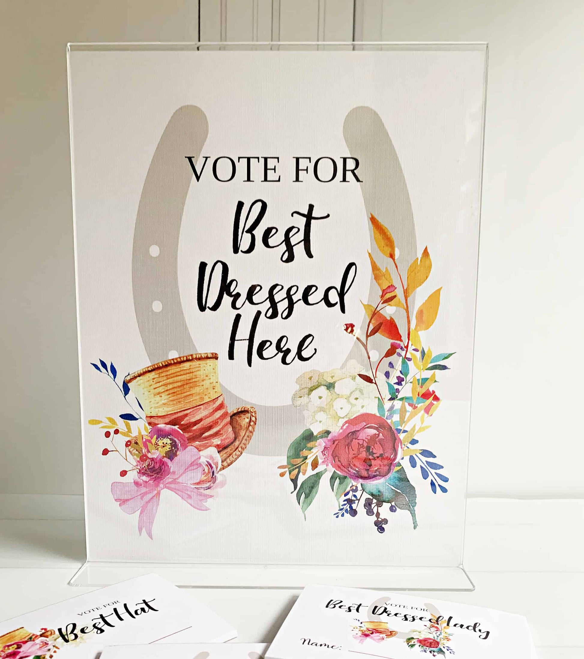 Create a fun and interactive experience at your Kentucky Derby party with EnFete's Derby "Vote for Best Here " Printed Sign.