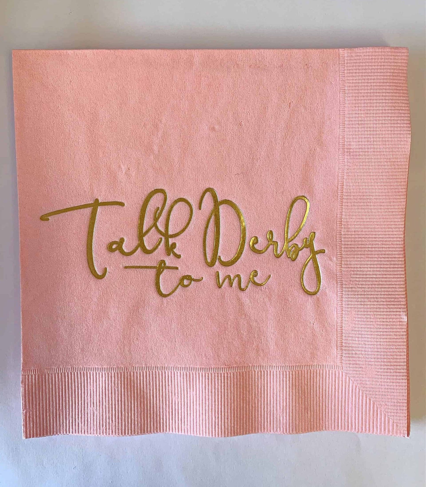 Talk Derby to me luncheon napkins in soft pink with gold foil writing - for a Kentucky Derby Bridal Shower or party Elevate your Kentucky Derby party with EnFete's original and elegant Kentucky Derby napkins. Add sophistication to your celebration. #KentuckyDerby #ElegantNapkins #EnFete.