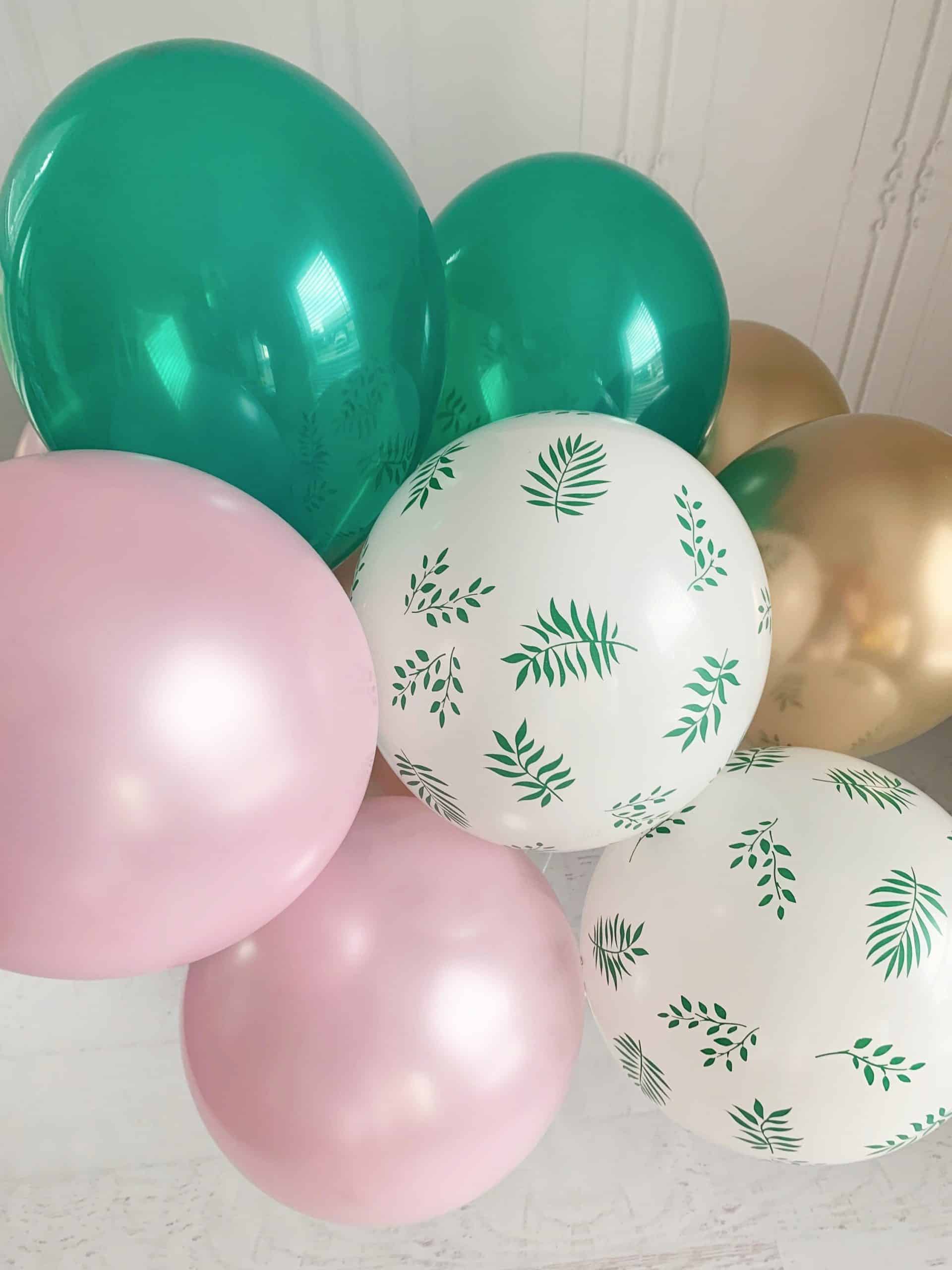Set of 12 Girl Dinosaur Balloons in shades of pink, green, gold, and tropical palm print. Perfect for decorating any dinosaur, tropical or fiesta themed party. Balloons are sold uninflated with assembly required.