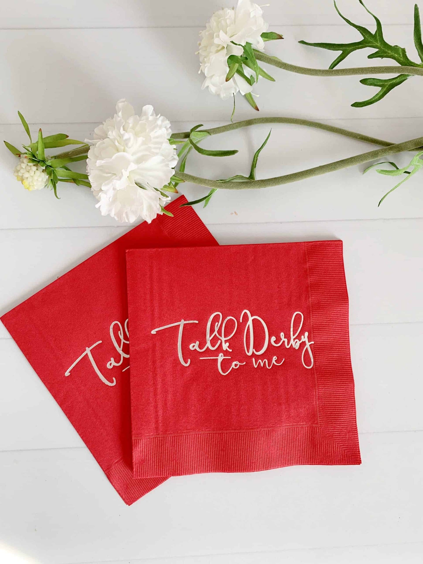 Get ready for the races with our "Talk Derby to Me" red cocktail napkins with silver lettering. These stylish napkins feature a bold red color and shimmering silver lettering, making them the perfect choice for a Kentucky Derby party or other special occasion. Whether you're serving cocktails, lemonade, or simply adding a touch of fun to your decor, these napkins are sure to impress. The durable construction ensures they are long-lasting and suitable for both indoor and outdoor events. So, get ready to rais