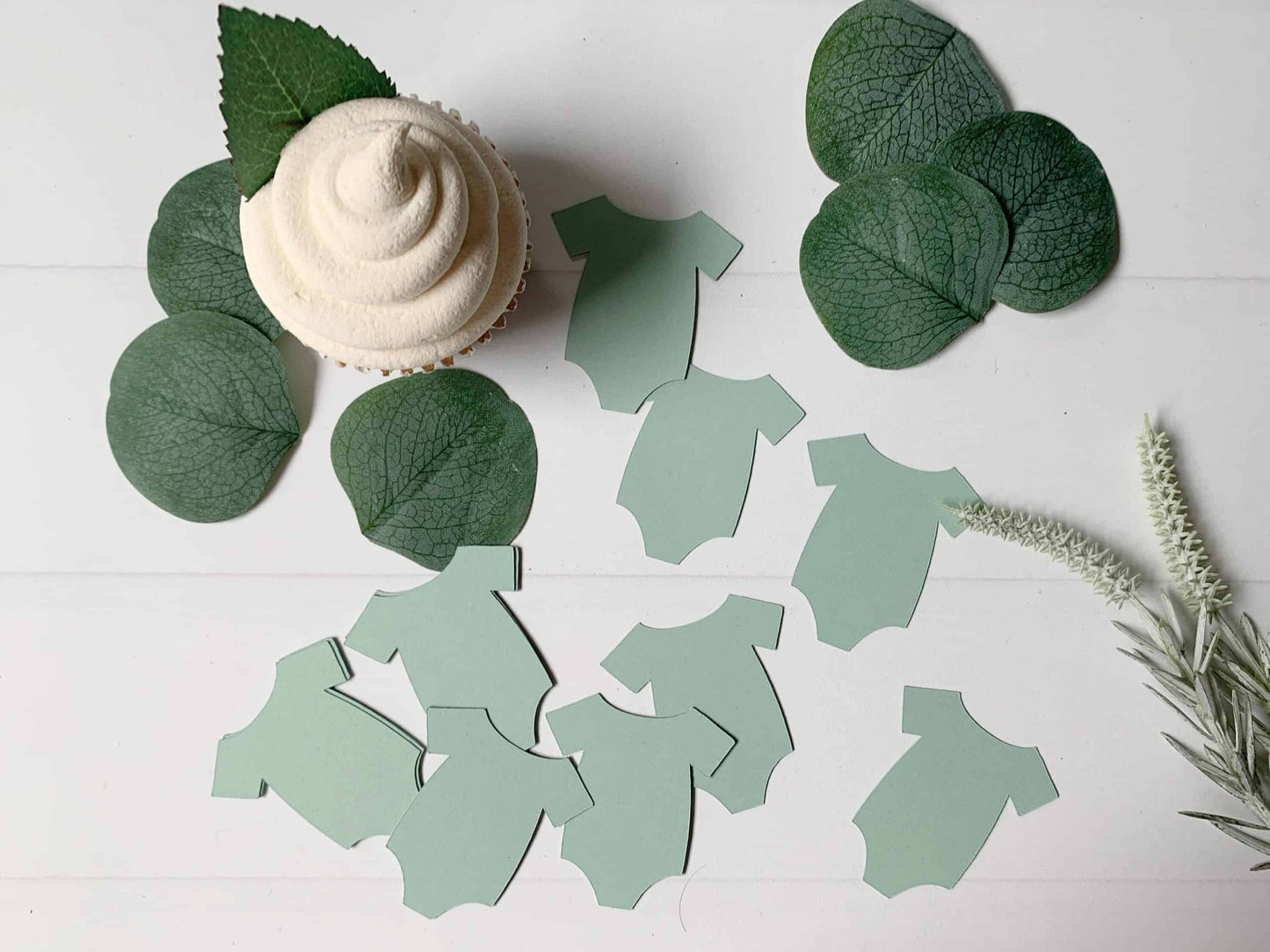 Shop our unique sage green onesie shaped confetti cutouts for the perfect addition to your baby shower. Add a pop of color to the celebration with our stylish and trendy confetti cutouts." #BabyShower #OnesieConfetti #SageGreen