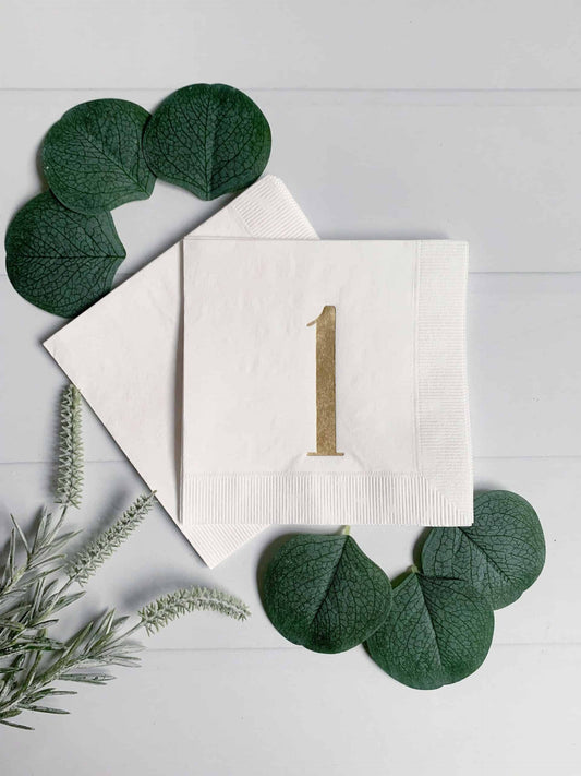 Elegant foiled gold 'one' cocktail napkins for a memorable first birthday celebration. #FirstBirthday #GoldFoil #CocktailNapkins #CelebrateInStyle 1st anniversary or birthday napkins