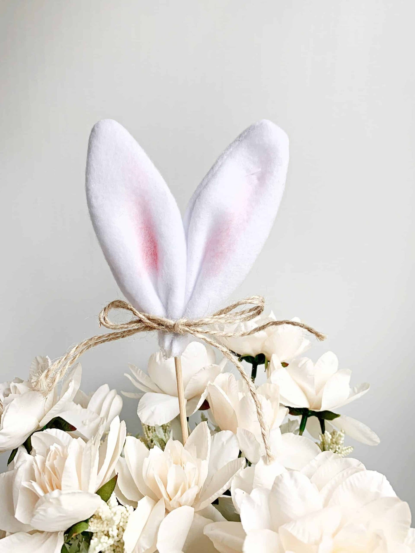 Add a touch of whimsy to your Easter celebration with our white bunny ears centerpiece pick. Perfect for decorating tables, baskets, and more. #Easter #BunnyEars #Centerpiece #TableDecor