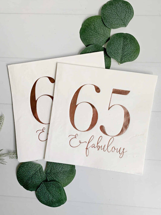 65 and fabulous rose gold napkins, perfect for a 65th birthday party, featuring a shiny metallic rose gold color and the message '65 and fabulous' in elegant font