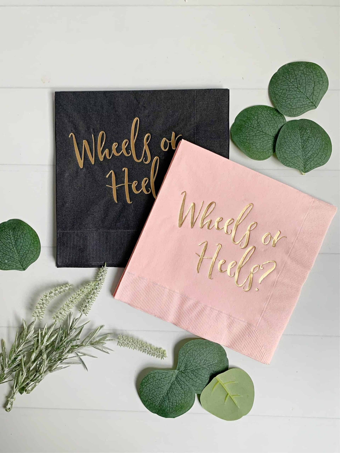 These fab black and pink gender-reveal paper napkins are the finishing touch for your gender-reveal party! Each napkin has a beautiful script "Wheels or Heels?" in gold foil. #genderreveal #babyshower #napkins #wheelsorheels #partydecor