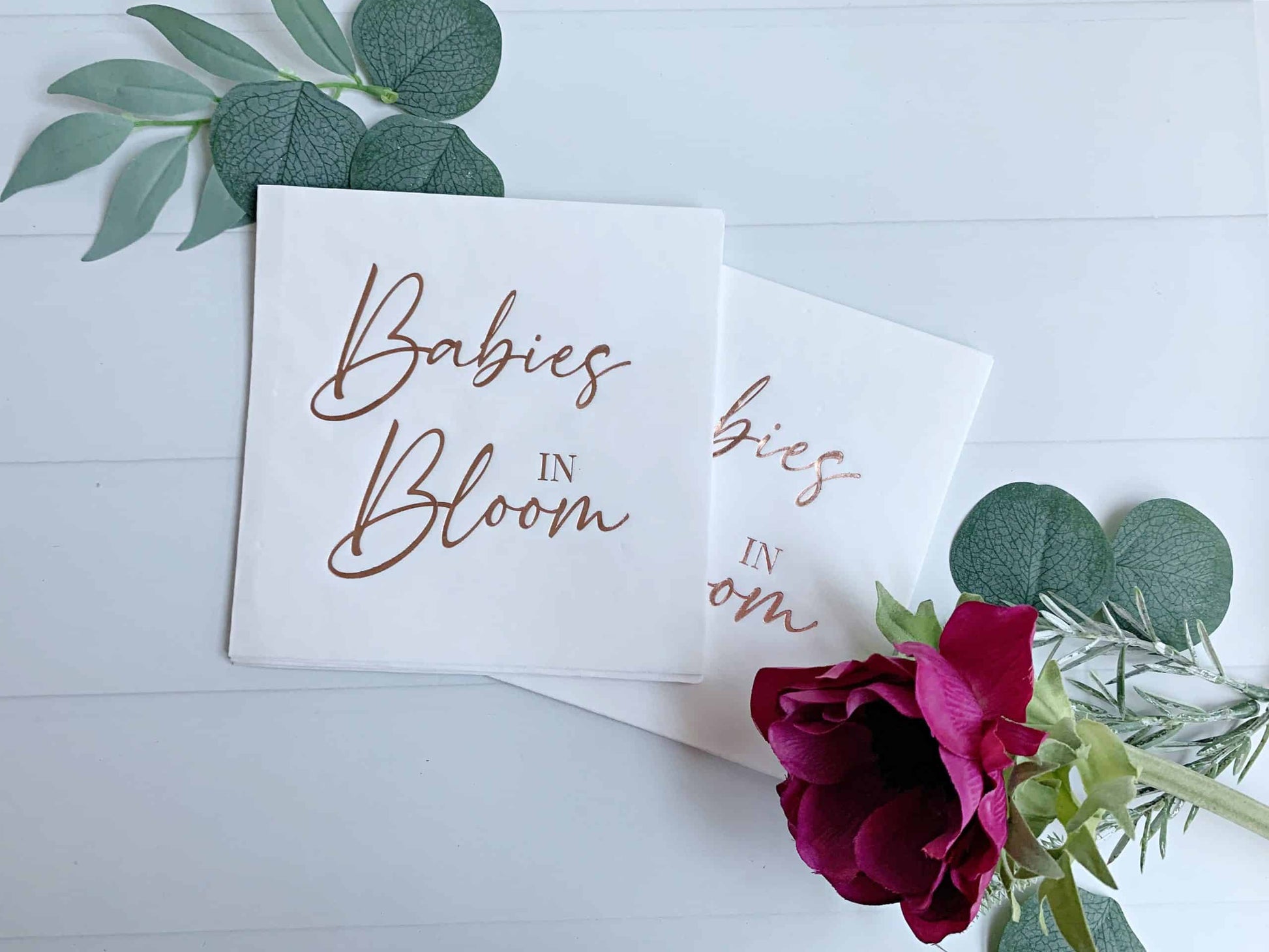"Babies in Bloom" in rose gold foil on white luncheon napkins - the perfect accent to your baby shower. Perfect for a baby shower for twins or mutiples. These gorgeous rose gold foiled "Babies in Bloom" napkins are an EnFete original product. You won't find them anywhere else!