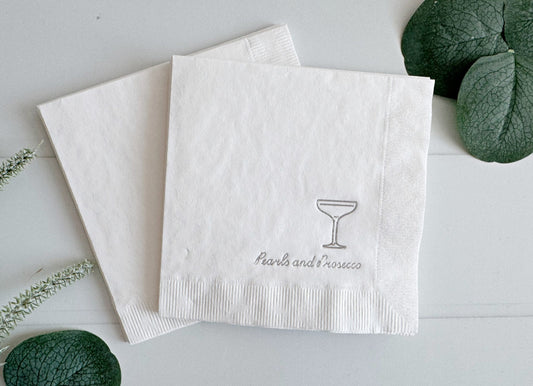 Introducing our silver "Pearls and Prosecco" Bridal Shower and Bachelorette Cocktail Napkins, the epitome of elegance and sophistication for your pre-wedding celebrations. These exquisite napkins feature a pristine white background adorned with intricate silver foil details