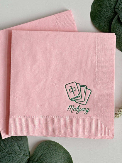 Elevate your game night with our exquisite Pink Mahjong Cocktail Napkins, designed to bring a touch of style to your gatherings. With a delicate green foil mahjong tile icon and the word "mahjong" elegantly scripted