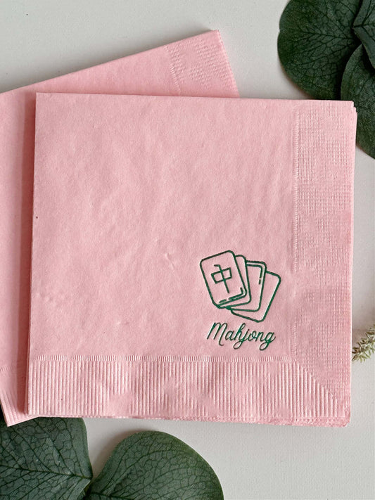 Elevate your game night with our exquisite Pink Mahjong Cocktail Napkins, designed to bring a touch of style to your gatherings. With a delicate green foil mahjong tile icon and the word "mahjong" elegantly scripted