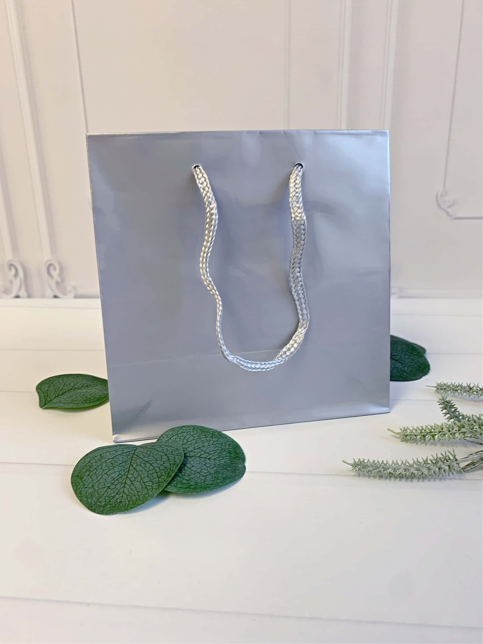 Add a touch of elegance to your holiday gift-giving with our Silver Gloss Gift Bags! Perfect for Christmas, winter-themed celebrations, and "Baby It's Cold Outside" baby showers