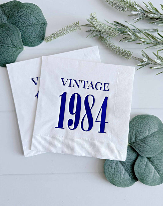 Elevate your celebration with a touch of nostalgia using our Vintage 1984 white with blue foil cocktail napkins. These meticulously crafted napkins pay tribute to the timeless charm of 1984 and are the perfect addition to your milestone birthday party or anniversary celebration.