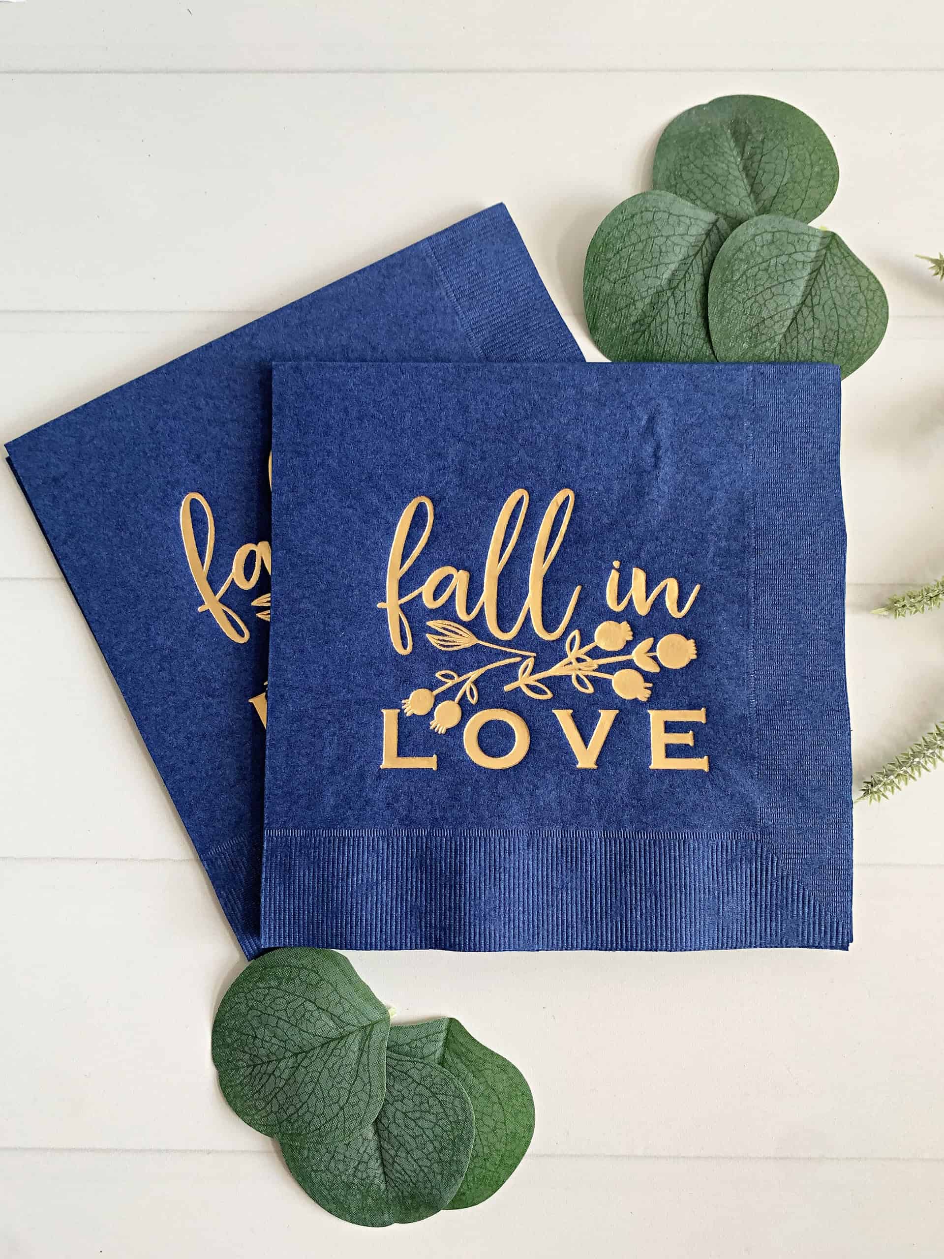 Three-ply tissue napkin, with a gold foil script Fall In Love on the front of each napkin. Perfect for a fall bridal shower or wedding. The perfect autumn engagement party, bridal shower, or wedding napkin. Elegant navy blue napkins with gold foil imprint.
