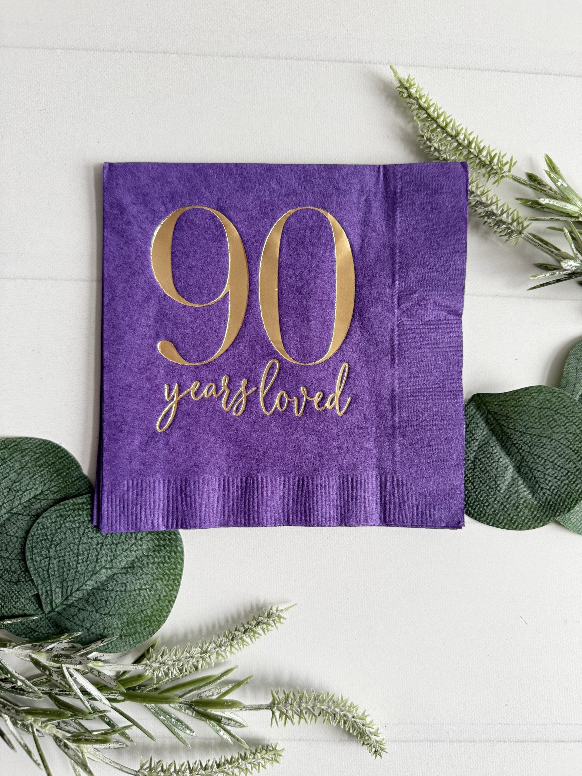 Raise a toast to 90 remarkable years with our purple "90 Years Loved" Cocktail Napkins featuring stunning gold foil accents! These napkins are the perfect addition to your 90th birthday celebration, adding a touch of elegance and style to commemorate this incredible milestone.