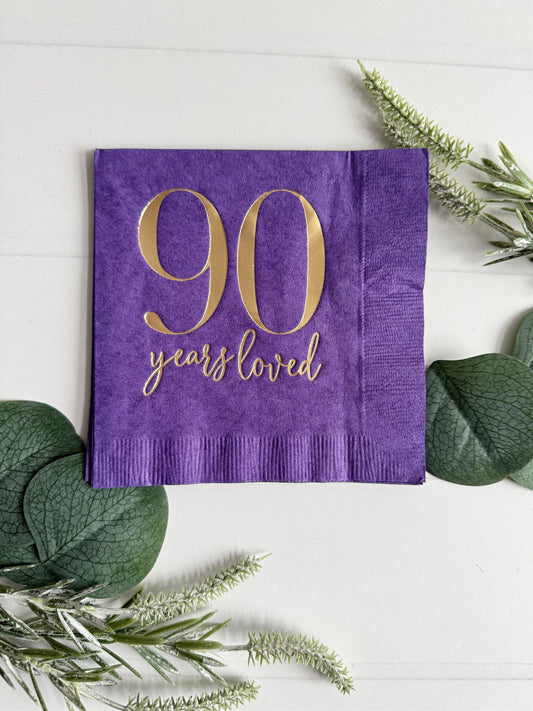 Raise a toast to 90 remarkable years with our purple "90 Years Loved" Cocktail Napkins featuring stunning gold foil accents! These napkins are the perfect addition to your 90th birthday celebration, adding a touch of elegance and style to commemorate this incredible milestone.
