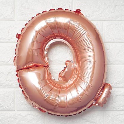 Rose gold Letter Q balloon on a white textured background