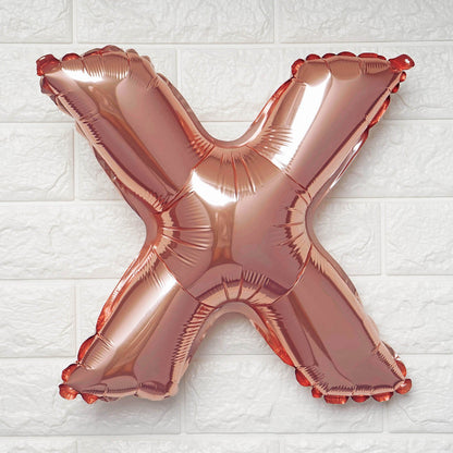 Rose gold letter 'X' balloon on a white textured background