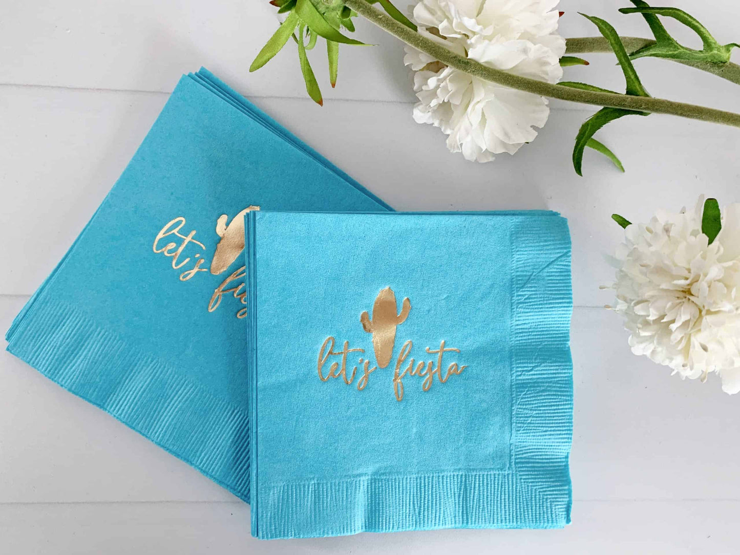 Let's fiesta napkins in turquoise with gold foil writing. Gold foil cactus in the middle. Perfect for Cinco de Mayo