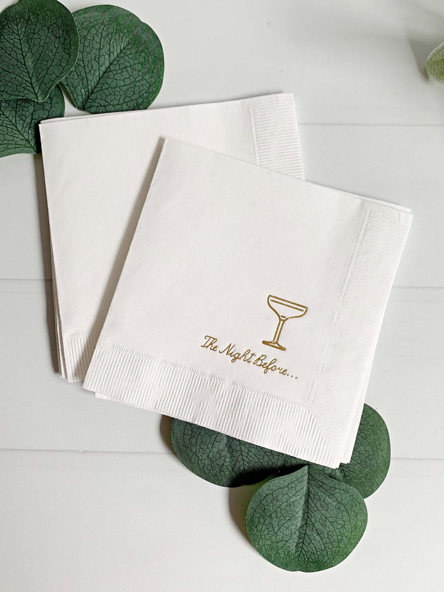 Add a touch of elegance to your rehearsal dinner with our "The Night Before" Elegant Cocktail Napkins. Each pack includes 16 white cocktail napkins, beautifully embellished with gold foil script that reads "the night before" paired with an elegant champagne coup glass icon.