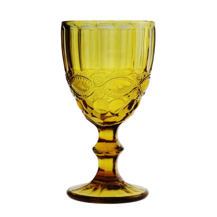 Yellow glass goblet with decorative patterns on a white background