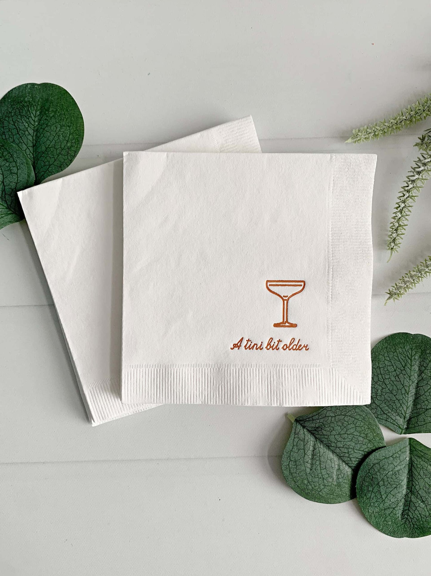 Enhance your birthday festivities by using EnFete's Copper "Just a Tini Bit Older" Birthday Cocktail Napkins. With a stylish social club design, these refined napkins showcase a espresso martini glass emblem and the phrase "Just a Tini Bit Older" in exquisite copper foil script. Ideal for 30th, 40th, 50th, or 60th birthday celebrations.