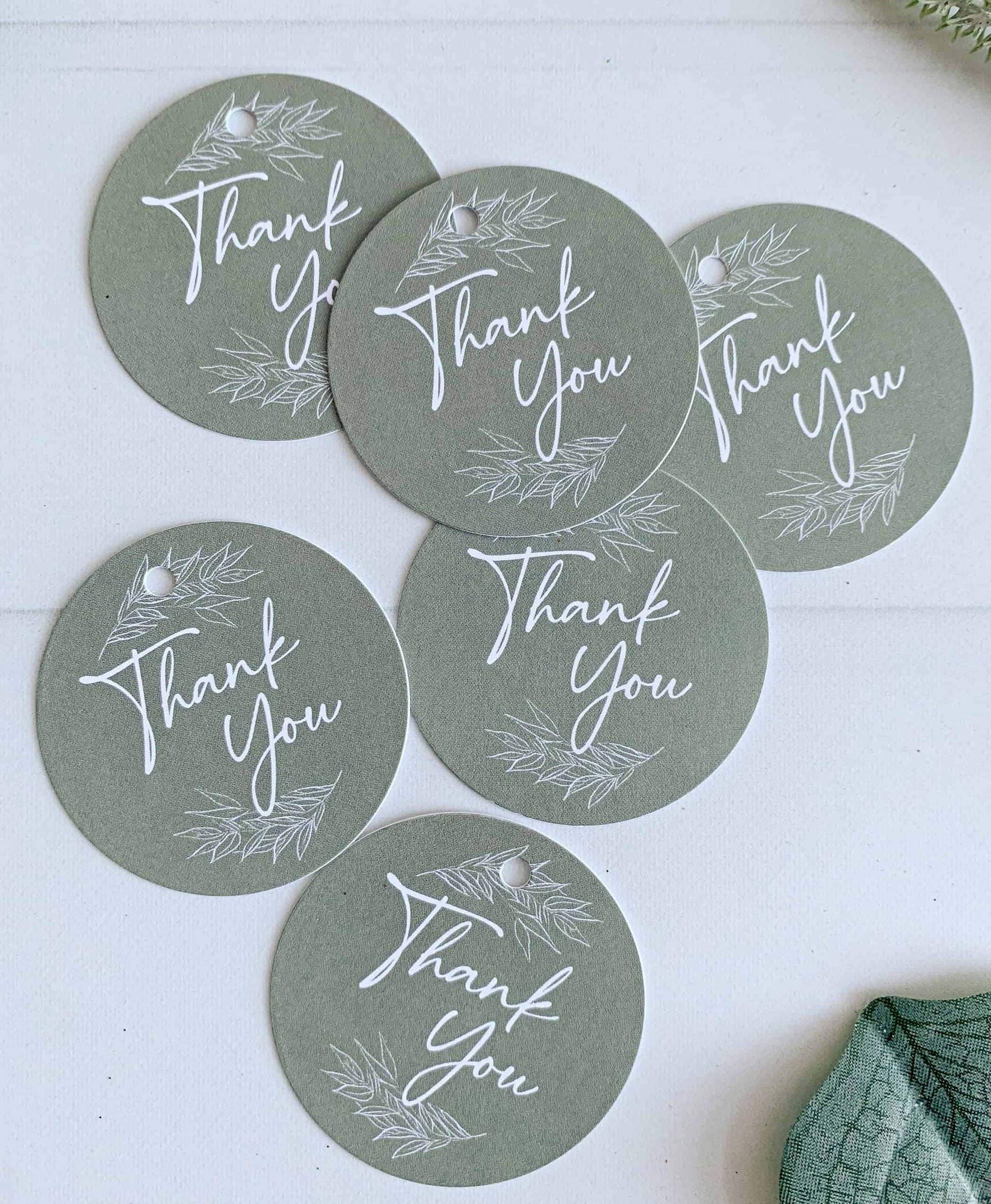 Elevate your gift-giving with our elegant Olive Green 'Thank You' Circular Tags. Each tag features a heartfelt "thank you" message surrounded by two delicate greenery branches, adding a charming and natural touch