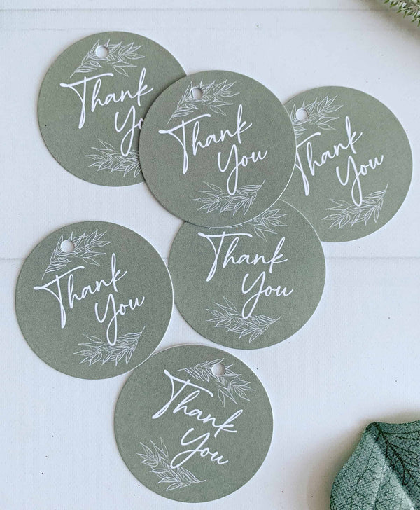 Elevate your gift-giving with our elegant Olive Green 'Thank You' Circular Tags. Each tag features a heartfelt "thank you" message surrounded by two delicate greenery branches, adding a charming and natural touch
