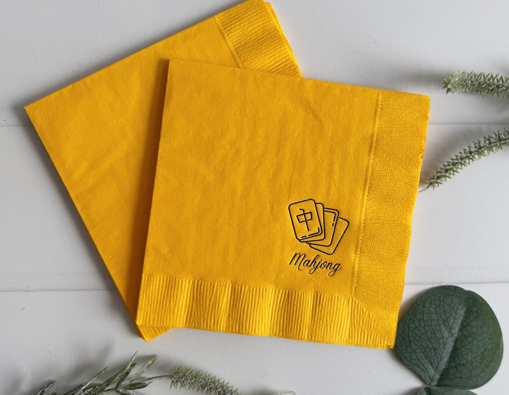 Elevate your game night with our Blue and Yellow Mahjong Cocktail Napkins. These napkins feature a sophisticated navy foil mahjong tile design, along with the word "mahjong" in a tasteful script font. Whether you're hosting a Mahjong gathering, a tea party, or any event that celebrates the intricacies of the game, these napkins are sure to impress.