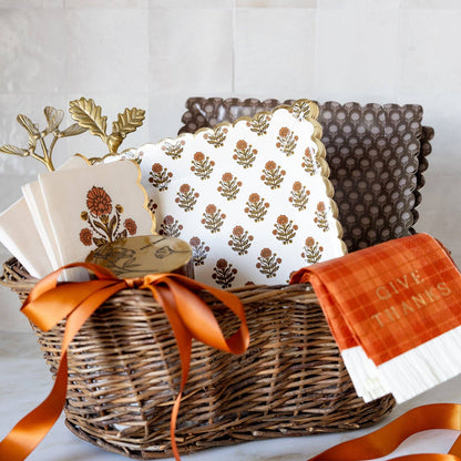 Decorative items including a wicker basket with an orange ribbon, a white pillow with floral pattern, and a red napkin with 'Give Thanks' text.