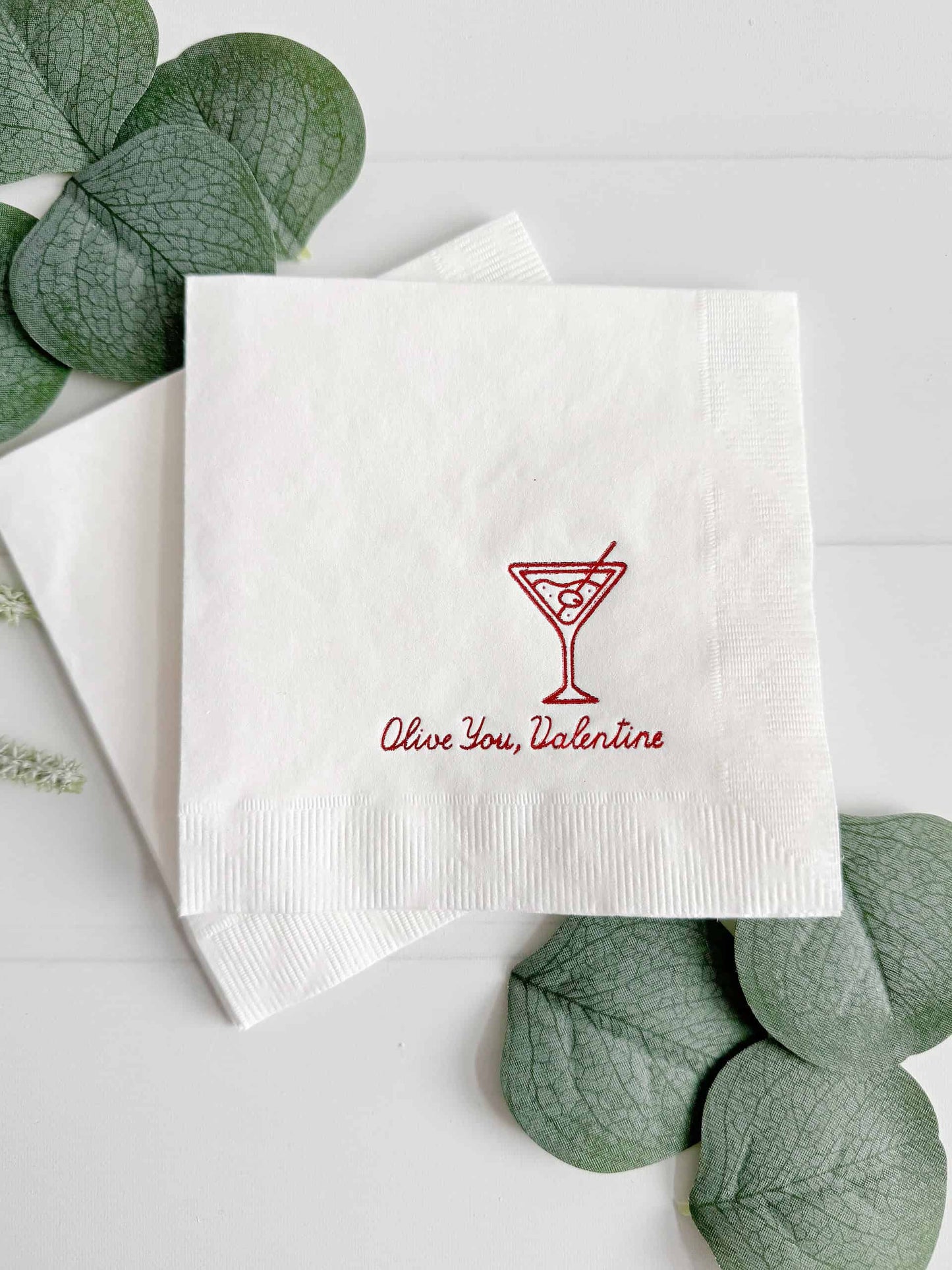 A fun set of cocktail napkins for Valentine's Day Celebrations - our "Olive You, Valentine" with martini glass (with an olive, of course!) Cocktail Napkins. These delightful napkins boast a pristine white hue, adorned with an elegant red foil design