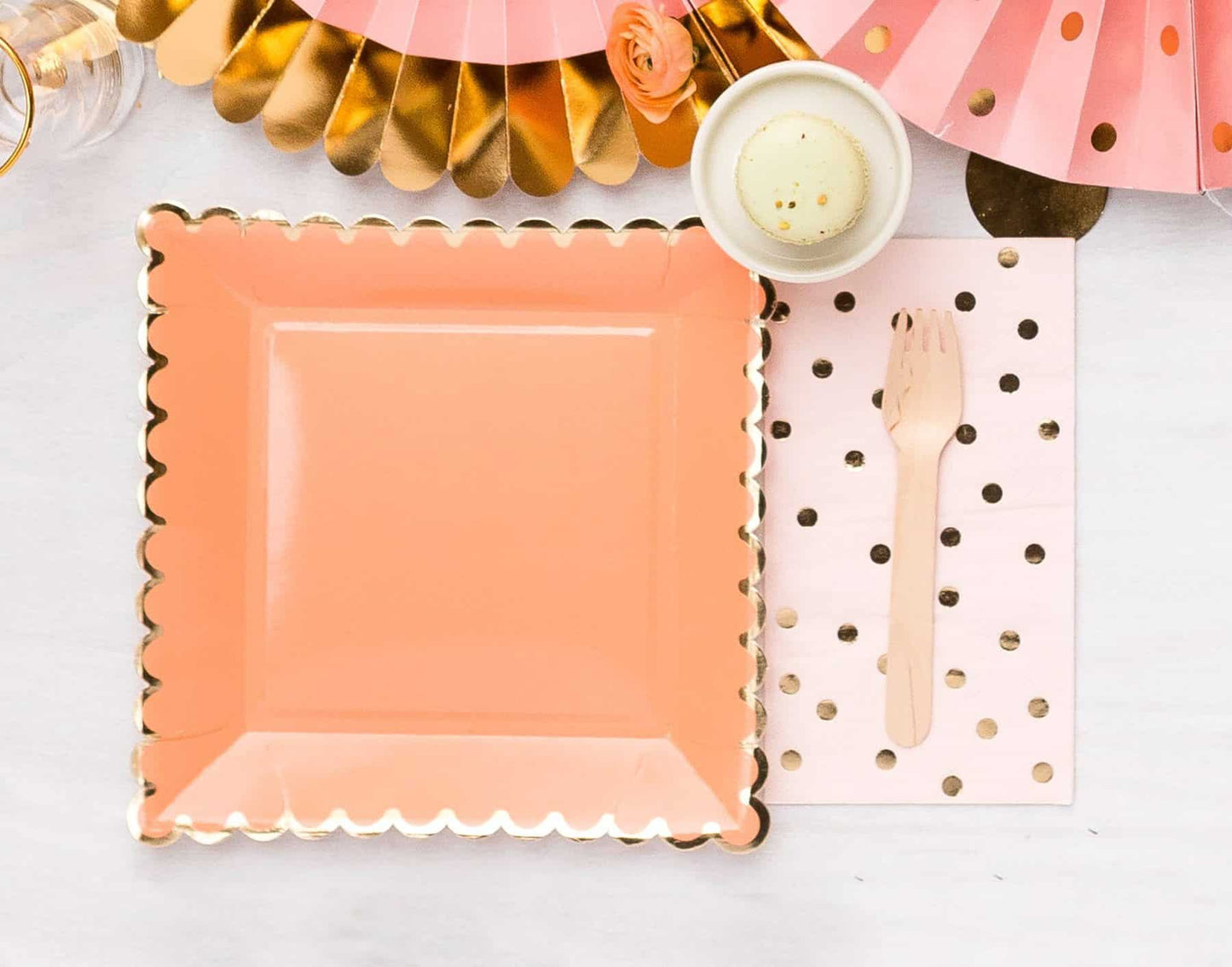 Peach square paper plates with a scalloped edge with a gold foil edge
