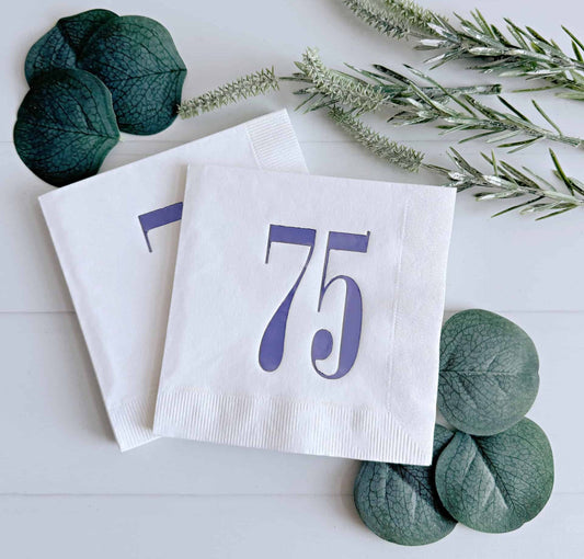 Introducing our eye-catching cocktail napkins featuring a bold retro lavender foil number 75 on a crisp white background. This design beautifully merges modern aesthetics with a touch of nostalgia, making it an ideal choice for celebrating a 75th birthday.