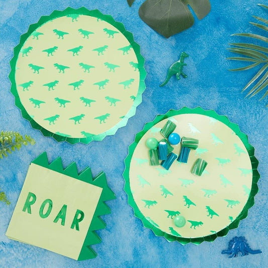 Dinosaur plates with a green foil detail next to dinosaur spiked napkins
