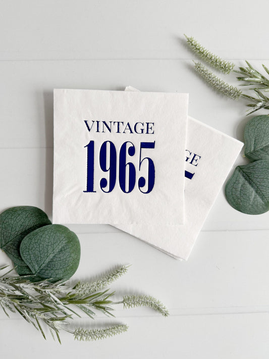 Elevate your celebration with a touch of nostalgia using our Vintage 1965 white with blue foil cocktail napkins. These meticulously crafted napkins pay tribute to the timeless charm of 1965 and are the perfect addition to your milestone 60th birthday party or anniversary celebration. Each pack contains 16 napkins measuring 4.75 x 4.75 inches, exuding vintage elegance and sophistication.