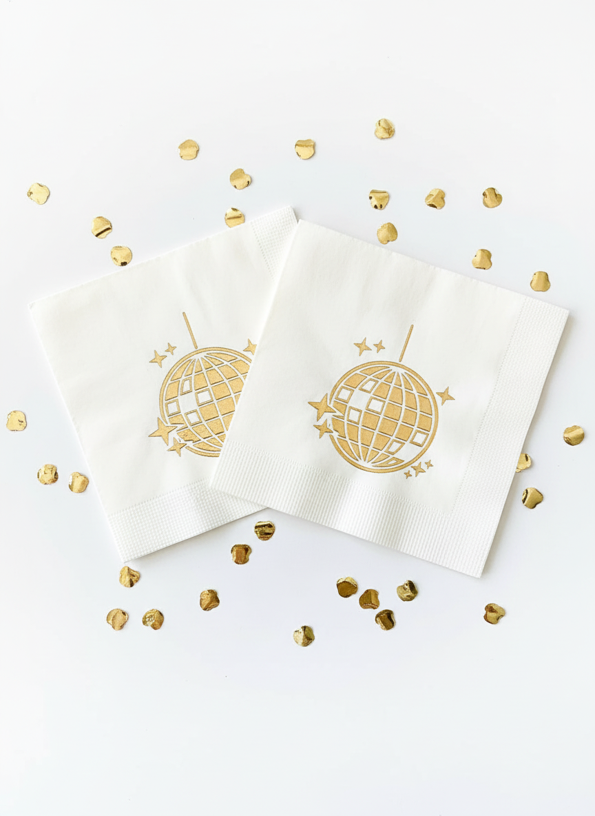 Gold disco ball napkins on white background with confetti